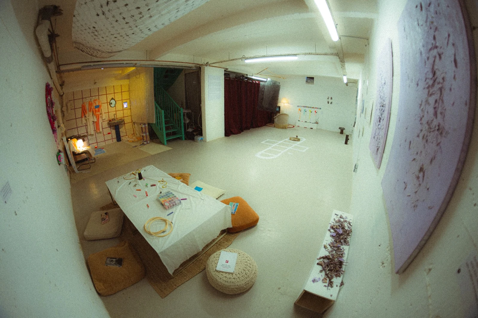 An overhead view across the low gathering table and cushions toward the rest of the gallery.