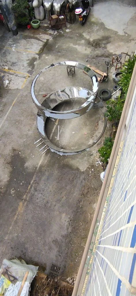An overhead workshop view of the sculpture’s metal components.
