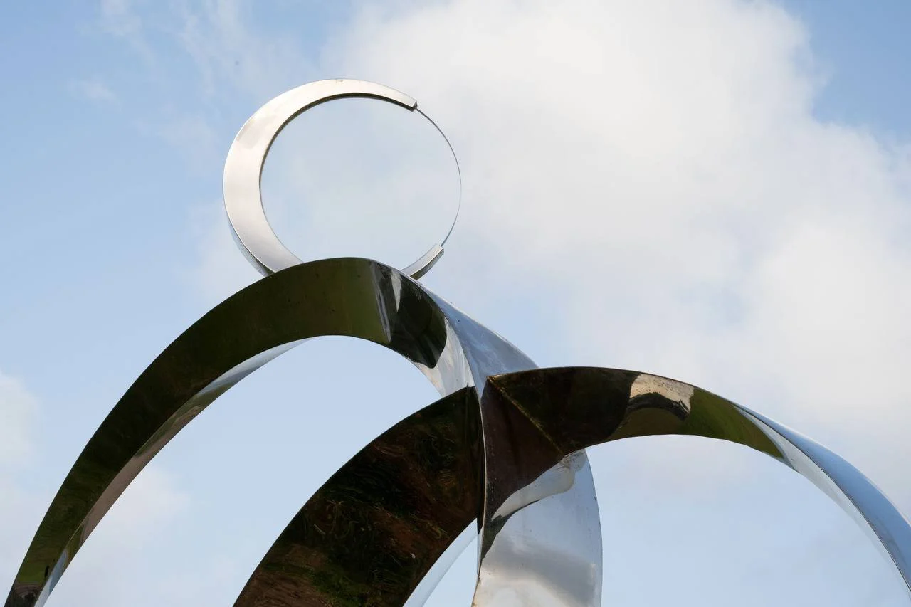 Close view of the reflective arcs and upper circular element of the finished sculpture.