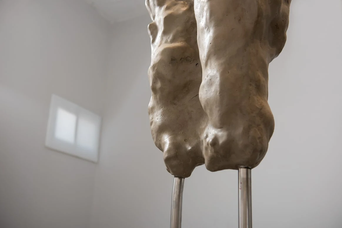 A close view of the textured sculptural surface where it meets its metal supports.
